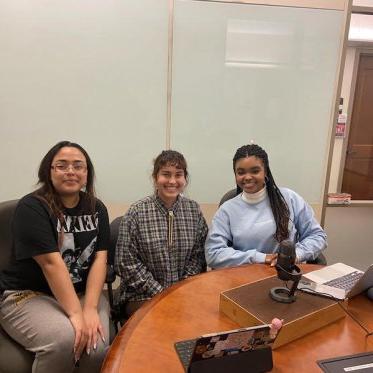 three women sitting and smiling