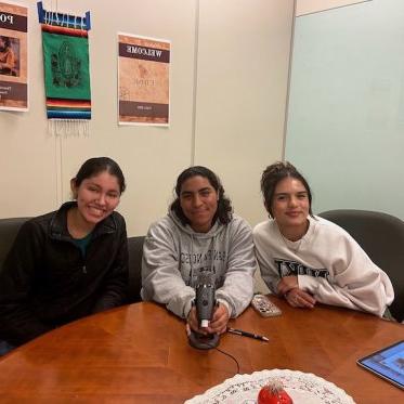 three women sitting and smiling