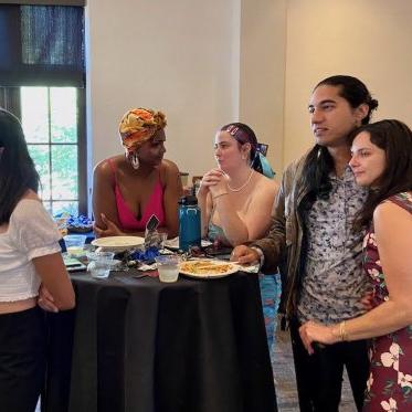 group of people standing around a table