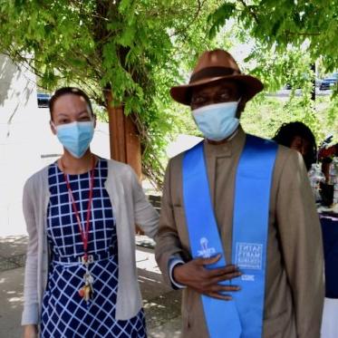 two people wearing mask standing and posing for picture