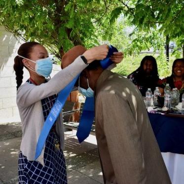 a girl helping a man to wear stole