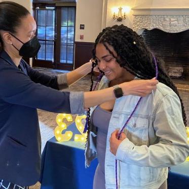 girl helping other girl to wear stole