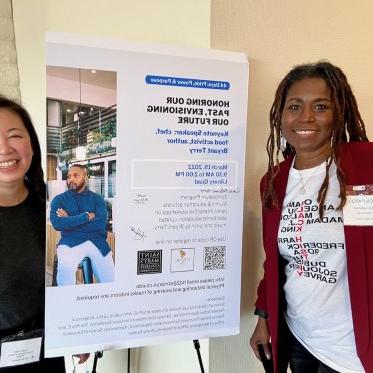 image of two women standing next to a poster