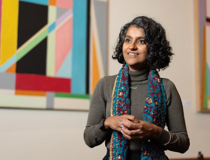 Bhattacharya in front of a colorful background